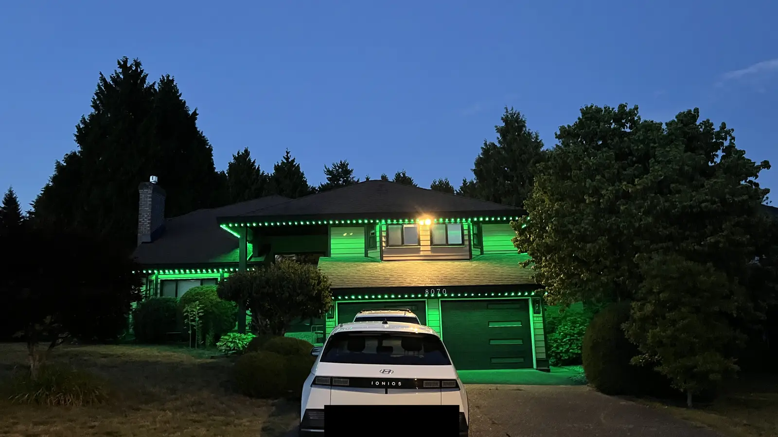 Vancouver home with permanent green LED roofline lighting at dusk by Vancouver Glow