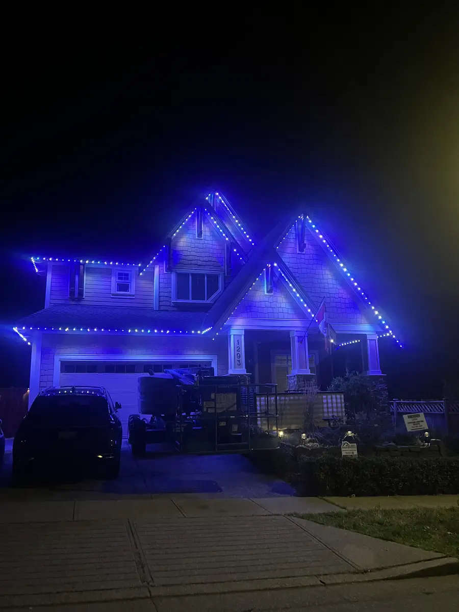 West Coast craftsman home with bright blue permanent LED roofline lighting installed by Vancouver Glow