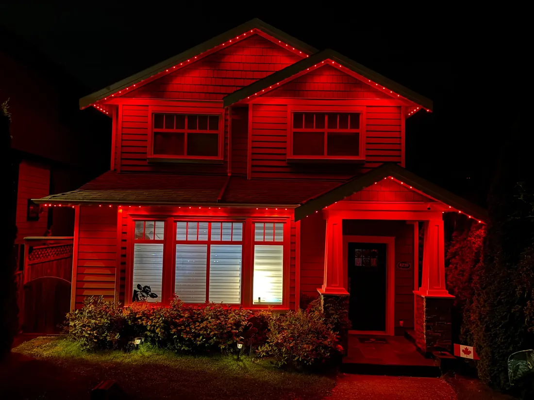 Vancouver craftsman home with red permanent LED roofline lighting installed by Vancouver Glow