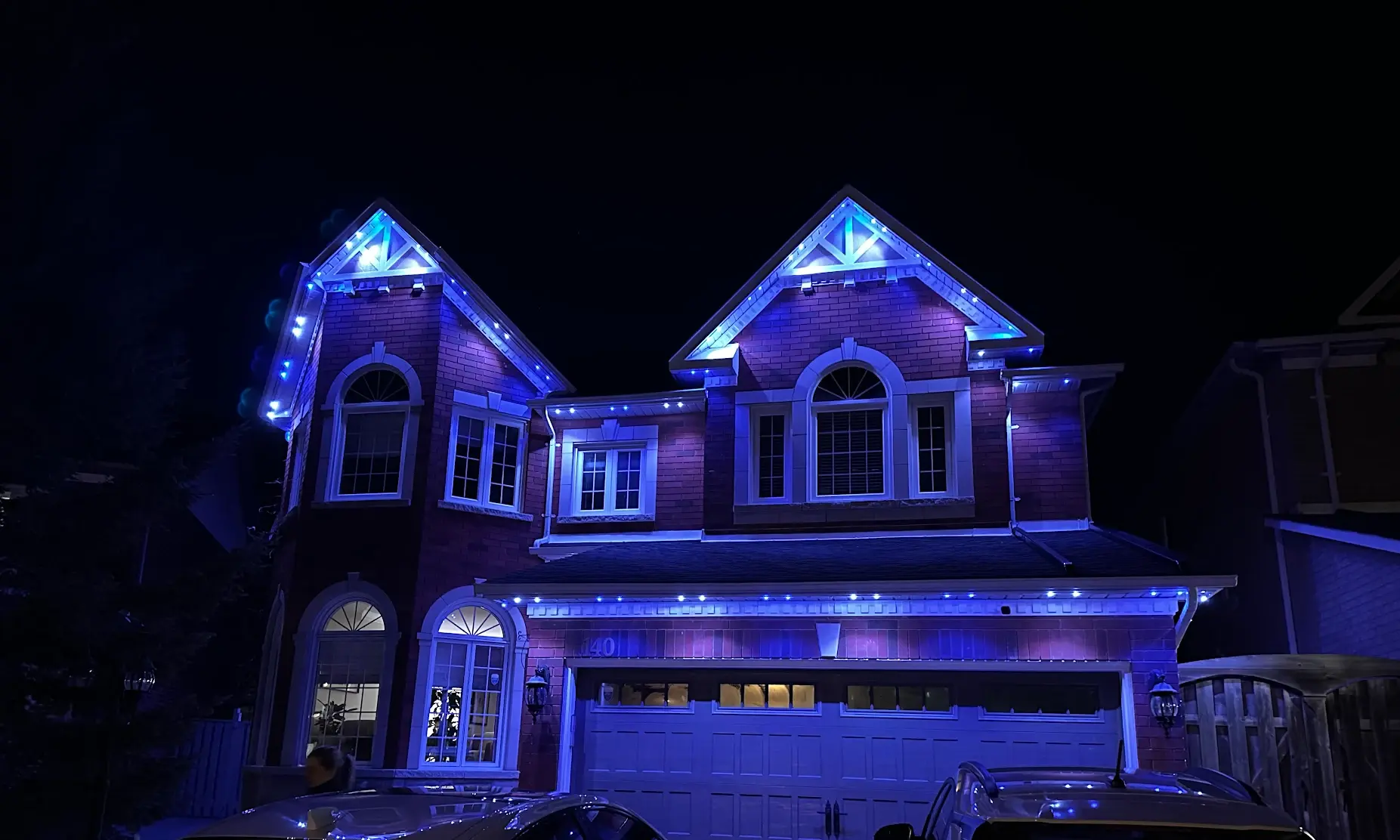 Home with blue permanent LED lights tracing peaks, eaves, and soffits at night by Vancouver Glow