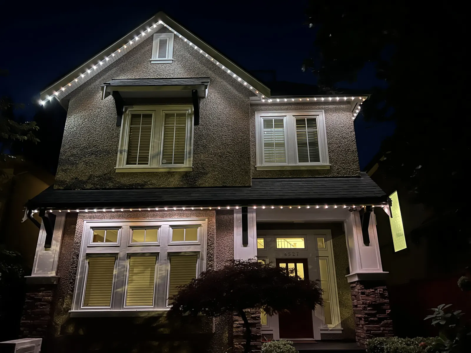 Vancouver home with elegant warm white permanent LED roofline lighting at night